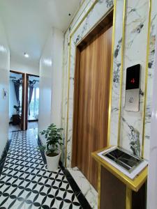 a hallway with a door and a potted plant at Hanoian Hotel in Dại Mõ