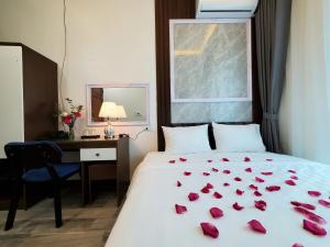 een slaapkamer met een bed met rozen erop bij Hanoian Hotel in Dại Mõ