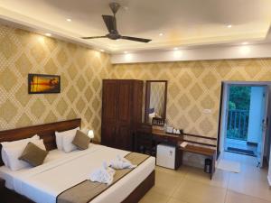 a bedroom with a bed and a desk in it at Pleasant Hill Resort in Munnar
