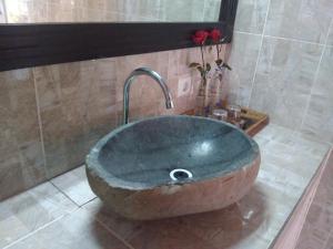 a large stone sink in a bathroom with at Ode Resto Guesthouse in Pemuteran