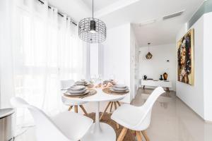 a white dining room with a white table and chairs at Casa Marietha Apartment with swimming pool and roof terrace in Rojales