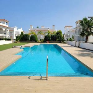 a large blue swimming pool in front of a building at Casa Marietha Apartment with swimming pool and roof terrace in Rojales