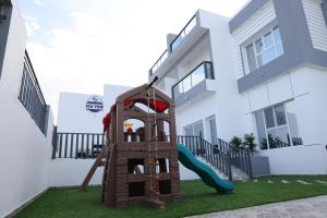 un parque infantil frente a una casa con tobogán en Sea View Chalet Al Ashkharah en Al Ashkharah