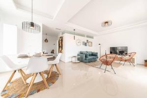 a white living room with a table and chairs at Casa Marietha Apartment with swimming pool and roof terrace in Rojales