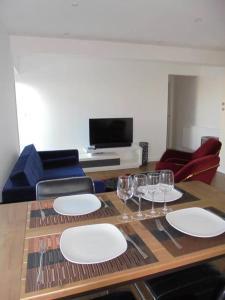 a table with plates and wine glasses on it at Beach Penthouse Apartment Bournemouth in Bournemouth