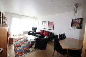 ein Wohnzimmer mit einem Sofa, Stühlen und einem Tisch in der Unterkunft Haus Norderhoog Wohnung 56 in Westerland