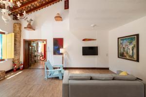 a living room with a couch and a tv at Pousada Vila do Porto in Paraty