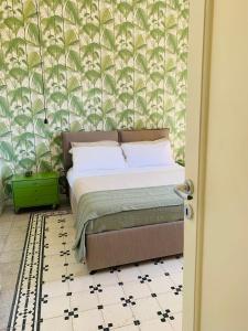a bedroom with a bed and a wall with palm leaves at Vista sul porto Ortigia in Syracuse