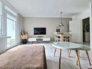 ein Wohnzimmer mit einem Tisch und einem TV in der Unterkunft Strandburg 1 in Grömitz
