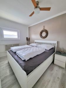 1 dormitorio con 1 cama grande y ventilador de techo en Strandburg 1 en Grömitz