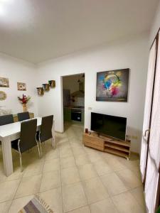 a living room with a television and a dining table at il Nido sul lago Trasimeno in Castiglione del Lago