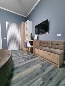 een woonkamer met een bank en een televisie bij Vila Egeus in Berat