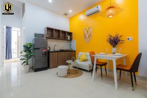 Luxury Condotel Sai Gon 2 في مدينة هوشي منه: مطبخ وغرفة طعام مع طاولة وجدار اصفر