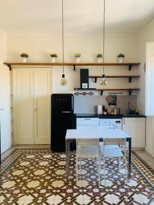 a kitchen with a table and chairs and a refrigerator at Vista sul porto Ortigia in Syracuse