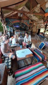 um grupo de pessoas sentadas em torno de uma mesa em uma loja em Seree Bungalows em Ko Chang