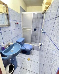a bathroom with a blue toilet and a sink at Sunrise Guest House in Huaraz