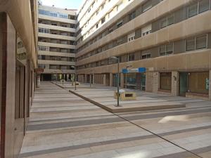 un patio vacío de un edificio de apartamentos con bancos en SunShine Tejares Garden, en Córdoba