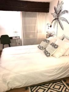 ein Schlafzimmer mit einem großen weißen Bett mit Kissen in der Unterkunft Au coeur du quartier historique in Montpellier