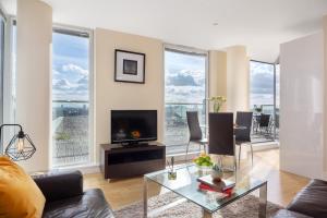a living room with a couch and a tv at Spacious Serviced Apartments Canary Wharf in London