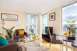 a living room with a couch and a table at Spacious Serviced Apartments Canary Wharf in London