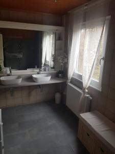 a bathroom with two sinks and a large mirror at Ferienhäuser Rhön - Haus Natalie & Haus Helene in Hausen +58 photos