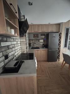 Apartament DELUX في جيشوف: مطبخ مع دواليب خشبية وثلاجة حديد قابلة للصدأ