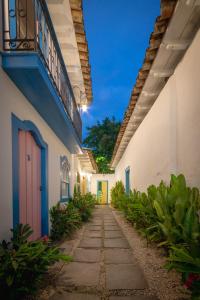 an alleyway with white buildings and a colorful door at Pousada Vila do Porto in Paraty
