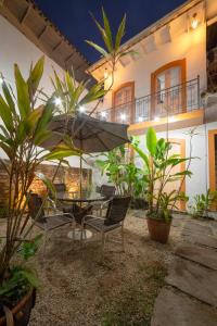 a patio with a table and chairs and an umbrella at Pousada Vila do Porto in Paraty