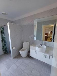 a bathroom with a toilet and a sink and a mirror at RELAX n RECOVER or WORK: HILLSIDE GETAWAY in Kelmscott