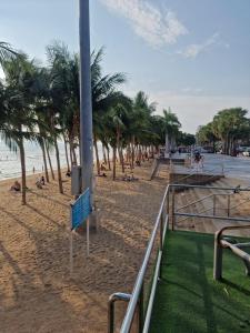 a sandy beach with palm trees and the ocean at Paradise Bar and Guesthouse 1 in Pattaya South
