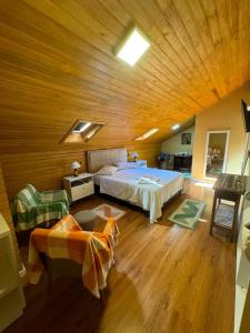 a bedroom with a large bed and a wooden ceiling at Recanto dos Jasmins Gramado in Gramado