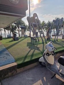 a scooter parked next to a playground with chairs at Paradise Bar and Guesthouse 1 in Pattaya South