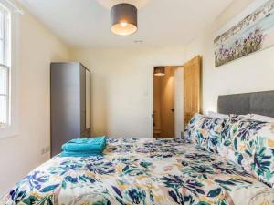 托基的住宿－Lovely Primrose Cottage Torquay，一间卧室配有一张带花卉床罩的床