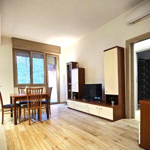 a living room with a dining table and a tv at BBking Appartamento Policlinico San Donato Milanese in San Donato Milanese