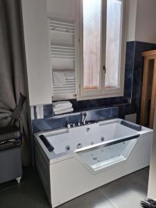 a white bath tub in a bathroom with a sink at Hotel Holiday- Alla Finestrella in Bologna