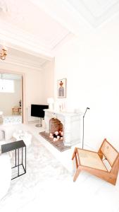 a white living room with a fireplace and a piano at Unique Mansion RL in Antwerp