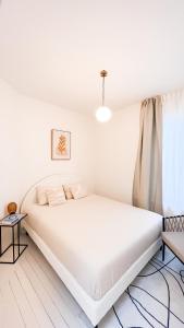 een witte slaapkamer met een bed en een raam bij Unique Mansion RL in Antwerpen