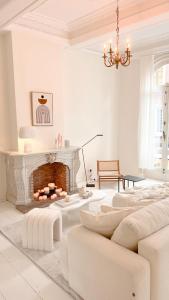 ein weißes Wohnzimmer mit einem Kamin und einem Kronleuchter in der Unterkunft Unique Mansion RL in Antwerpen