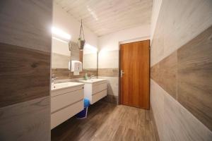 ein Badezimmer mit zwei Waschbecken und einer Holztür in der Unterkunft PLANINSKA KOČA NA GOZDU in Kranjska Gora