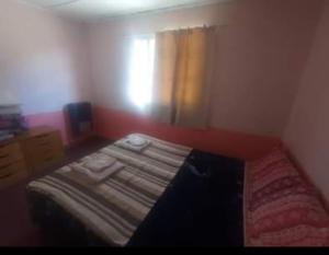 ein Schlafzimmer mit einem Bett in einem Zimmer mit einem Fenster in der Unterkunft La Casita in Tecka