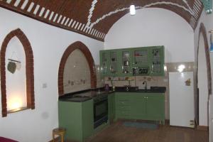 a kitchen with green cabinets and an arched ceiling at Mogran Guest House in Luxor