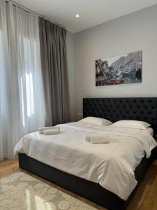 a large bed in a bedroom with a large window at Vila Panto in Tirana