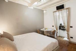 een slaapkamer met een wit bed en een tafel bij Fiori Suite in Rome +2 foto's