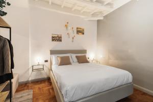 een witte slaapkamer met een groot bed met witte muren bij Fiori Suite in Rome
