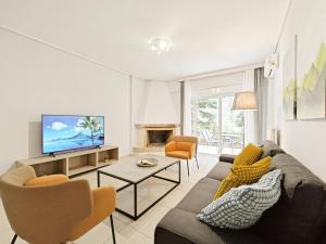 een woonkamer met een bank en een tv bij Omorfokklisias Apartments by Verde in Athene