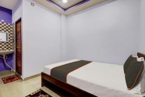 a bedroom with a bed and a desk at Super Collection O Ashirbad Lodge in Guwahati