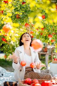 a woman is holding tomatoes in an apple orchard at Apple house cafe in Ban Rong Fong