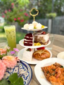 a table topped with plates of desserts and a drink at Apple house cafe in Ban Rong Fong