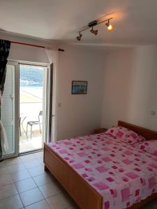 1 dormitorio con 1 cama grande y balcón en Rab Island Apartments Del Sole, en Supetarska Draga