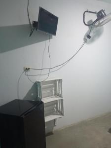 a television with a wire hanging from a wall at La posada del amor in Máncora